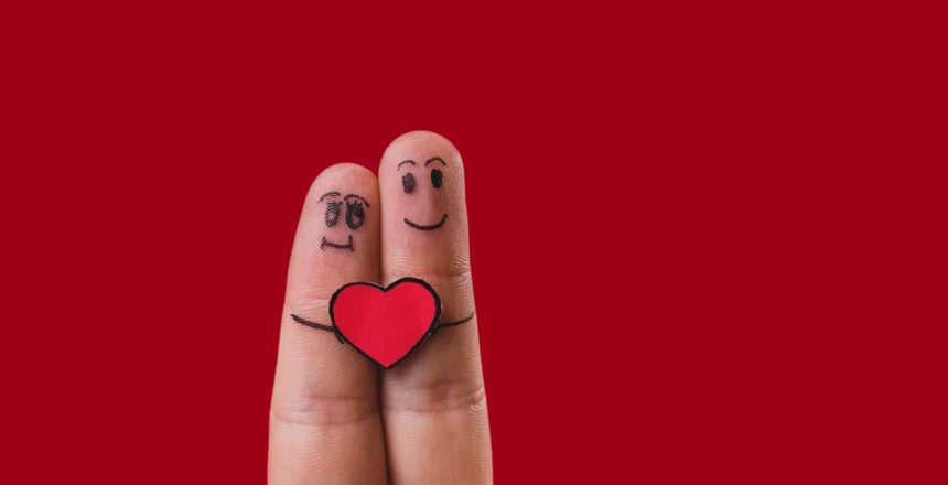 Deux doigt collé avec petits personnages dessinés dessus tenant un petit coeur, représentant l'amour